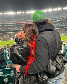 a man and woman standing next to each other at a football game