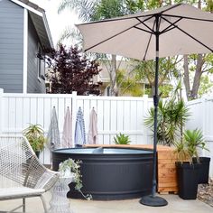 an outdoor hot tub with umbrella and chairs