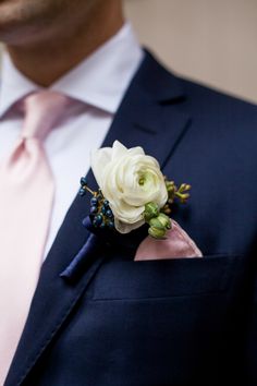 a man in a suit and tie with a boutonniere on his lapel