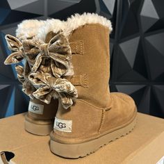 Women’s Bailey Bow Crushed Velvet Uggs Soft Sheepskin Tan Velvet Upper Fixed Velvet Bow Along Back Shaft 17mm Uggplush 80% Upcycled Wool, 20% Lyocell Lining 17mm Uggplush 80% Upcycled Wool, 20% Lyocell Insole Foam Footbed Treadlite By Ugg Outsole For Comfort Polyester Binding Or 100% Recycled Polyester Binding Woven Heel Label With Ugg Logo Mcbling Clothing, Ugg Collection, Uggs Women, Shoes Uggs, Cute Uggs, Uggs With Bows, Jordan Shoes Retro, Shoes Retro, Bailey Bow