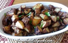 a white bowl filled with cooked potatoes on top of a table