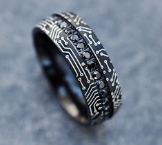 a black and white ring with an electronic circuit board pattern on it's side