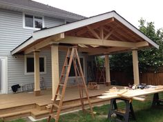 a wooden deck with ladders next to it and a picnic table in the foreground