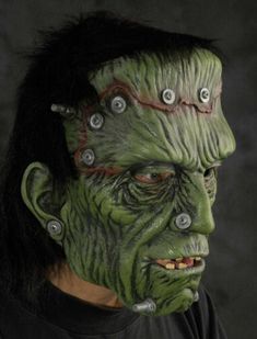 a man with green makeup and piercings on his face