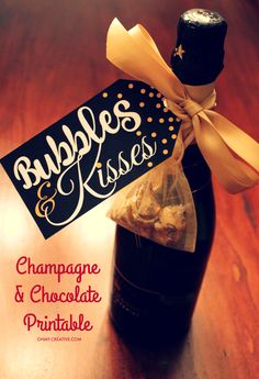 a bottle filled with champagne and chocolate covered pretzels on top of a wooden table