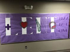 a purple banner with the word love written on it in front of a gray wall