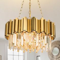 a gold chandelier hanging from the ceiling in a room with white walls and windows