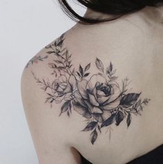 the back of a woman's shoulder with flowers and leaves on her left side