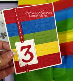 a person holding up a card with the number three on it