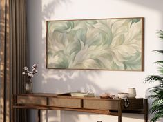 a painting hanging on the wall next to a wooden table with vases and plants