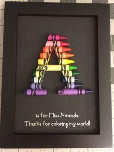 there is a black frame with colored crayons in the shape of a letter