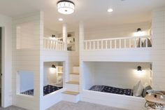 two bunk beds are in the middle of a room with white walls and carpeted flooring