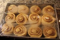 there are many rolls wrapped in plastic on the counter and ready to be baked into buns