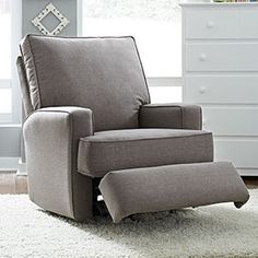 a gray recliner chair sitting on top of a white rug in a living room