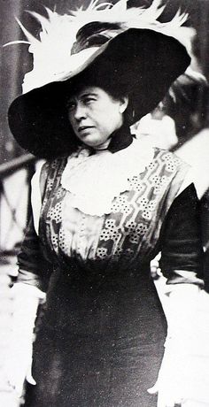 an old black and white photo of a woman wearing a hat