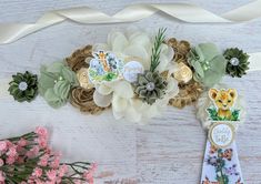 some flowers are sitting next to each other on a white table with ribbon around it