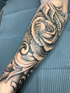 a man's arm with an intricate tattoo design on it