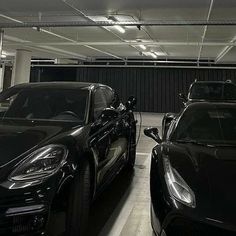 two black cars parked in a parking garage