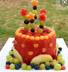 a cake decorated with fruit and stars on top