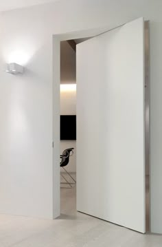 an open door leading to a white room with a desk and chair in the background