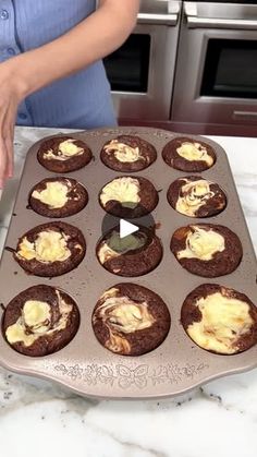 a woman is making cupcakes with frosting in the middle on a pan