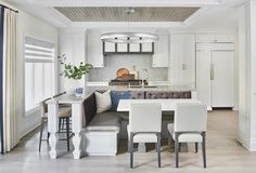 a kitchen and dining room with white furniture