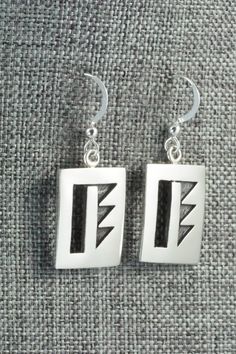 These sterling silver earrings are made by Hopi silversmith Timothy Mowa. The backs are signed and stamped sterling.Length: 1 3/8"Width: 5/8"Free shipping on all orders! We ship with USPS and always include tracking. All orders ship within a day of payment.Returns are accepted up to 30 days after you receive your order. Just send us a message. Our shop offers cash back or store credit. The item must be returned in new condition. Silver Symbolic Rectangular Jewelry, Unique Sterling Silver Rectangular Earrings, Symbolic Hallmarked Sterling Silver Earrings, Traditional Sterling Silver Rectangular Jewelry, Traditional Rectangular Sterling Silver Jewelry, Native American Jewelry, Free Jewelry, Sterling Silver Earrings, Silver Earrings