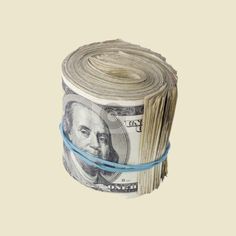 one hundred dollar bill tied up to a roll of blue string on a beige background