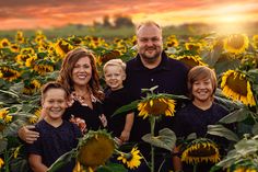 a family poses for a photo in a field of sunflowers