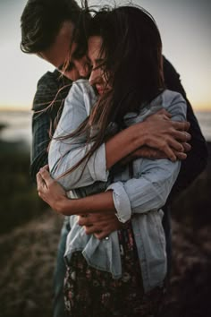 two people hugging each other while standing next to each other