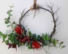 a wreath with red flowers and green leaves