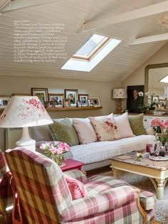 a living room filled with furniture and pictures on the wall next to a table topped with flowers