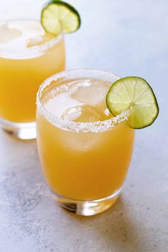 two margaritas with lime and salt garnish on the rim