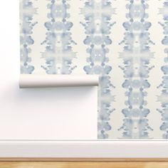 a wall with a blue and white pattern next to a roll of paper on the wall