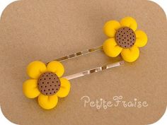 two yellow flower hair pins with holes in the middle on a brown background that says petite false