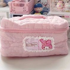 a pink suitcase sitting on top of a table next to stuffed animals and other toys