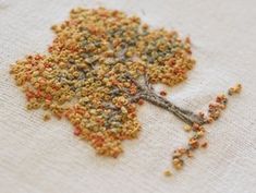 a close up of a cross stitch pattern on a piece of cloth with tiny flowers