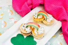 small pastries with rainbows and sprinkles on a plate