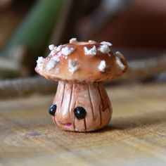 a small toy mushroom sitting on top of a wooden table