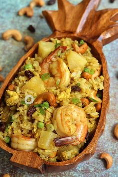 a wooden bowl filled with rice and shrimp