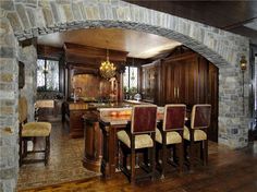 a large kitchen with an archway leading into the dining room