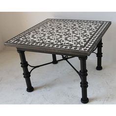 a black and white tiled table with metal legs