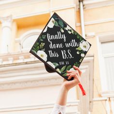 a person holding up a graduation cap that says finally done with this b s