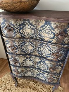 an old dresser with a basket on top