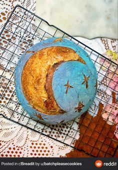 a blue and yellow baked item on a wire rack with a lace doily behind it