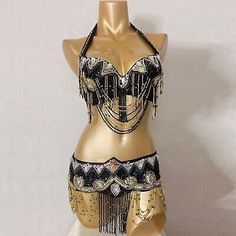 a mannequin is dressed in gold and black with beads on the bustle