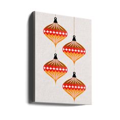 three red and gold ornaments hanging from strings on a white canvas print wall art piece