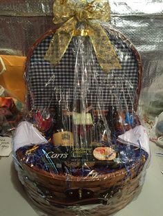 a basket filled with wine and snacks on top of a table