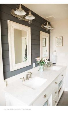 a bathroom with two sinks and mirrors on the wall