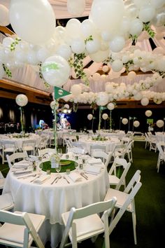 tables and chairs are set up with white balloons